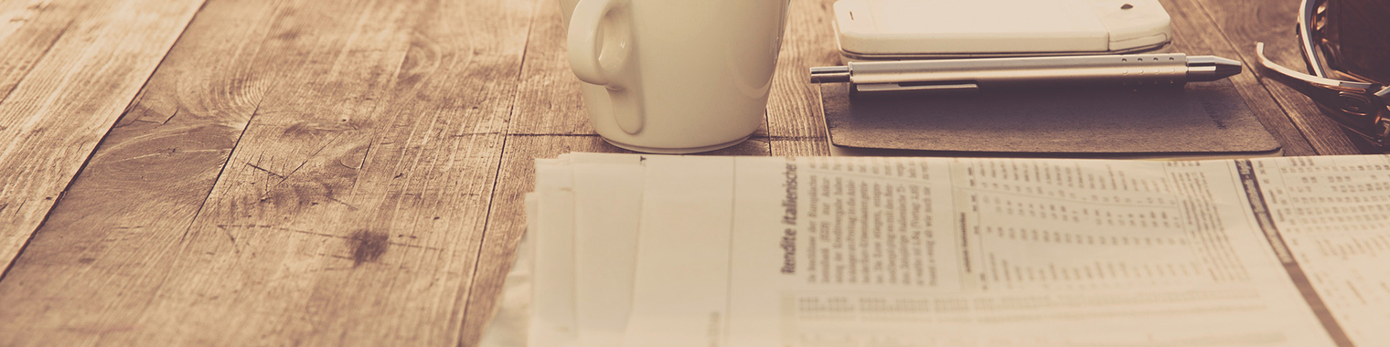 Newspaper, phone, and a coffee cup