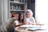 Older adult woman with granddaughter and cell phone