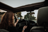 Woman driving a car and looking at her cell phone