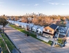 Aerial view of row houses with city skyline behind them