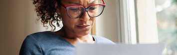 Worried woman considers bill.