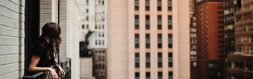 Woman on balcony in New York City.