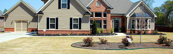 Large home with for-sale sign.