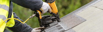 Person installing new roof on house.