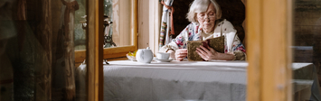 Older woman reading at a table 