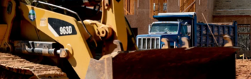 Bulldozer in front of housing construction.