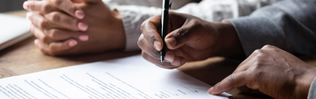 Two people signing homeownership documents.