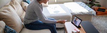 Older woman in home taking zoom call on tablet.