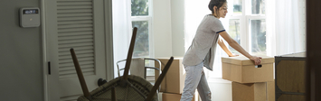 Woman unpacking boxes in new home.