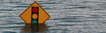 Street sign submerged in flood water.