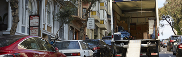 Moving truck parked on steep residential street.