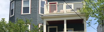 View of blue triple decker house facade.