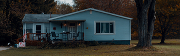 Small ranch house by roadside.