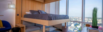The Ori Cloud Bed, seen here at The Greenpoint apartments in New York City, rises into the ceiling to reveal the sofa below.