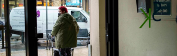 Older women with walker at entrance of her apartment building.