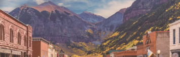 View of small town's main street, with mountains in background.