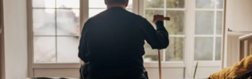 Aging man looking out of window