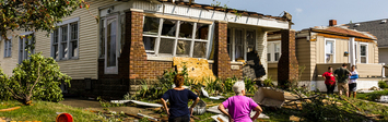 People outside a damaged home.