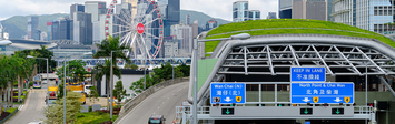 Highway and tunnel against Hong Kong skyline.