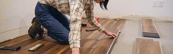 Asian woman installing click flooring
